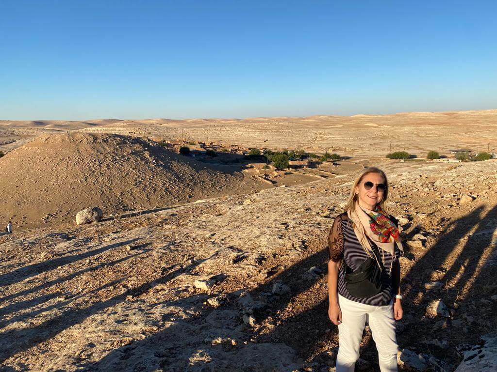 woman standing by wall holding mug